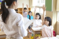 授業中挙手をする小学生